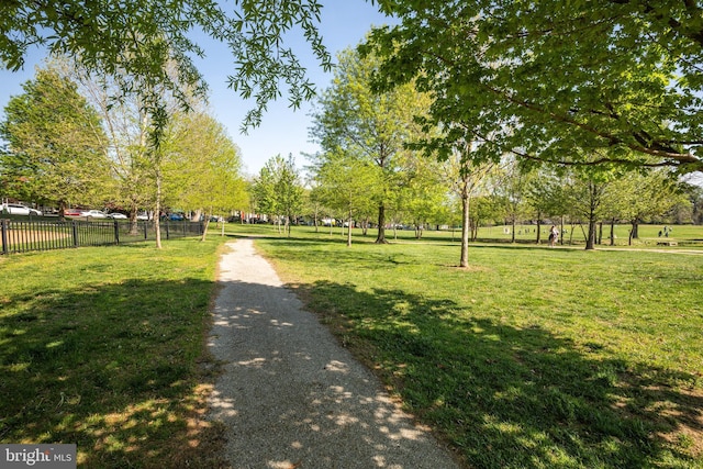 view of community with a lawn and fence