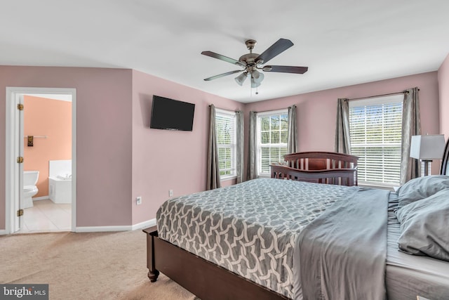 carpeted bedroom featuring baseboards, ensuite bathroom, and a ceiling fan