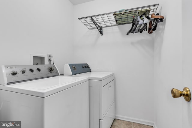 clothes washing area with laundry area, washer and clothes dryer, and baseboards