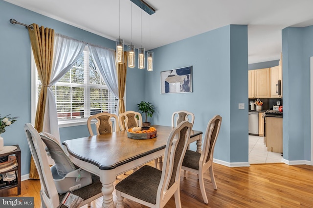 dining area featuring baseboards and light wood-style flooring