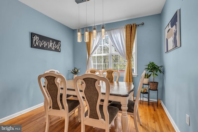 dining room with baseboards and light wood-style flooring
