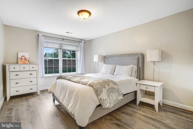 bedroom with baseboards and wood finished floors