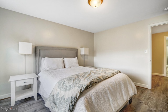 bedroom featuring wood finished floors and baseboards