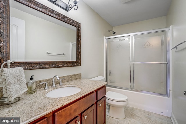 bathroom with toilet, vanity, and combined bath / shower with glass door