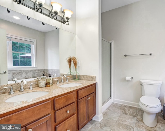 full bathroom featuring a stall shower, toilet, double vanity, and baseboards
