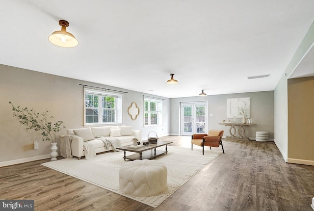 living room with plenty of natural light, wood finished floors, and baseboards