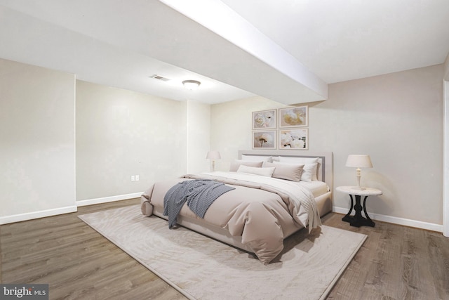 bedroom featuring wood finished floors and baseboards