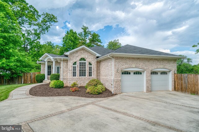view of front of property with concrete driveway, brick siding, fence, a garage, and a shingled roof