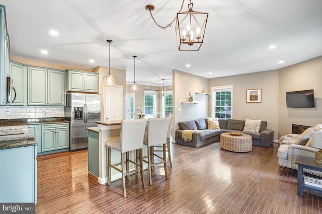 kitchen featuring appliances with stainless steel finishes, open floor plan, a chandelier, a breakfast bar, and recessed lighting