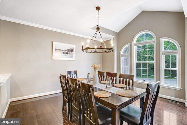 dining space featuring hardwood / wood-style flooring, baseboards, a chandelier, vaulted ceiling, and crown molding