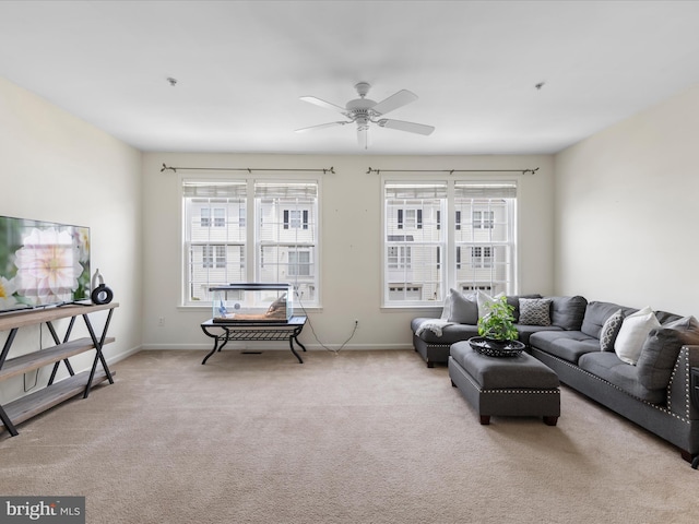 carpeted living area featuring ceiling fan and baseboards