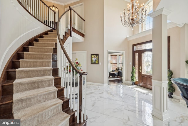 entryway with stairs, a high ceiling, a notable chandelier, and marble finish floor