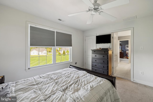 carpeted bedroom with baseboards, a ceiling fan, and visible vents