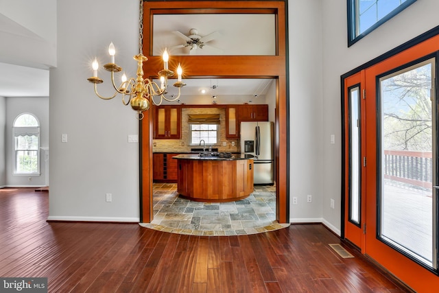 kitchen featuring brown cabinets, baseboards, visible vents, and stainless steel fridge