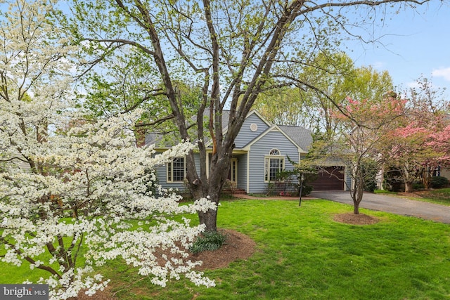 view of front of home featuring aphalt driveway, a front yard, and a garage