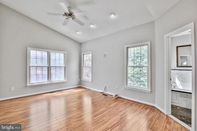 spare room with plenty of natural light, lofted ceiling, ceiling fan, and wood finished floors