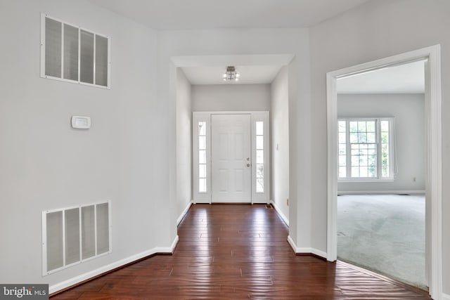 entrance foyer with baseboards, visible vents, a notable chandelier, and dark wood finished floors