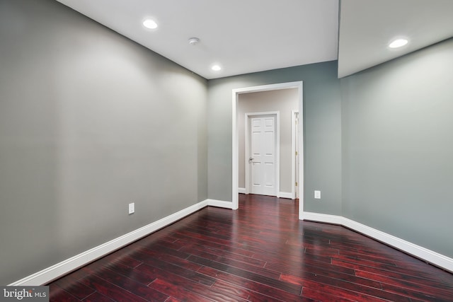 empty room featuring baseboards, hardwood / wood-style floors, and recessed lighting