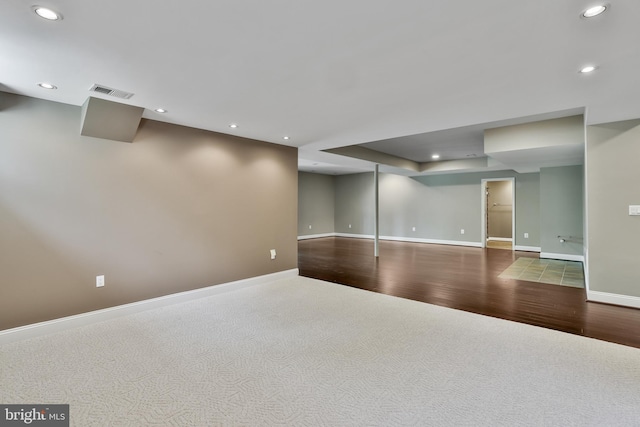 unfurnished room featuring baseboards, visible vents, recessed lighting, wood finished floors, and carpet floors