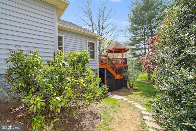 view of yard with a gazebo, a wooden deck, and stairway