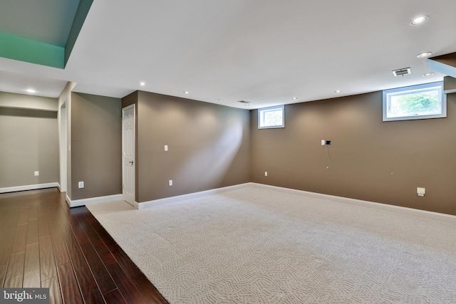 below grade area featuring recessed lighting, wood finished floors, visible vents, and baseboards
