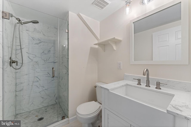 bathroom with vanity, toilet, visible vents, and a stall shower