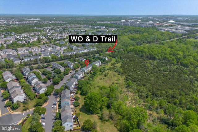 drone / aerial view featuring a residential view and a wooded view