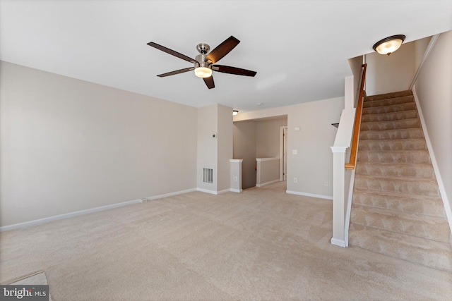 unfurnished living room featuring visible vents, carpet floors, stairs, baseboards, and ceiling fan