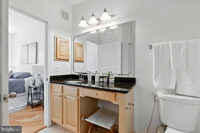 12000 Market St Unit 189, Reston, VA 20190 - bathroom with toilet, vanity, visible vents, and wood finished floors