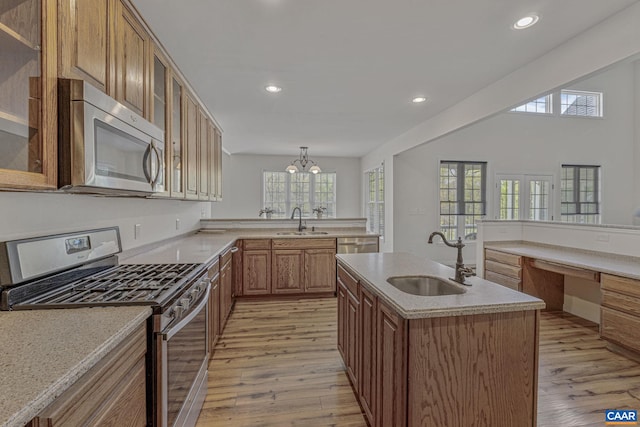 kitchen featuring recessed lighting, light wood-style flooring, appliances with stainless steel finishes, and a sink