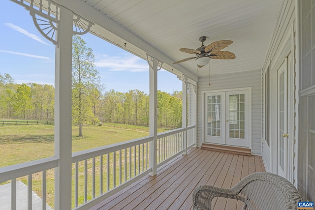 wooden deck with a lawn, a ceiling fan, and french doors