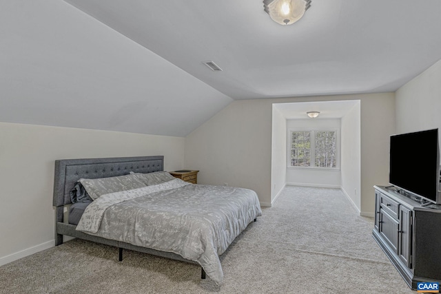 bedroom featuring lofted ceiling, visible vents, baseboards, and light carpet