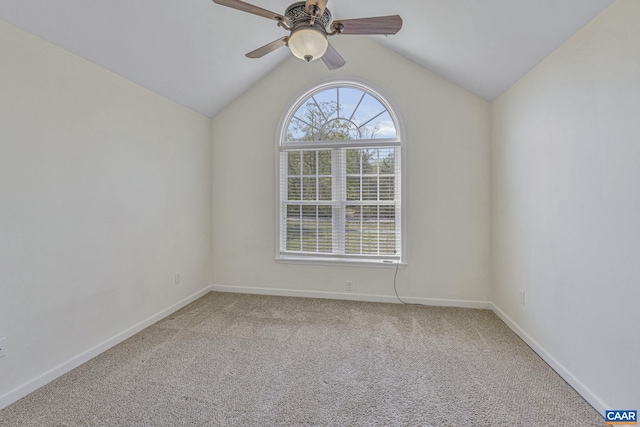 carpeted empty room featuring a ceiling fan, baseboards, and vaulted ceiling