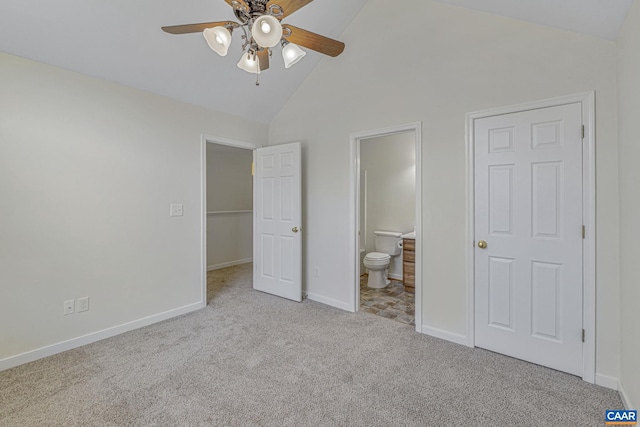 unfurnished bedroom featuring high vaulted ceiling, connected bathroom, ceiling fan, baseboards, and carpet flooring