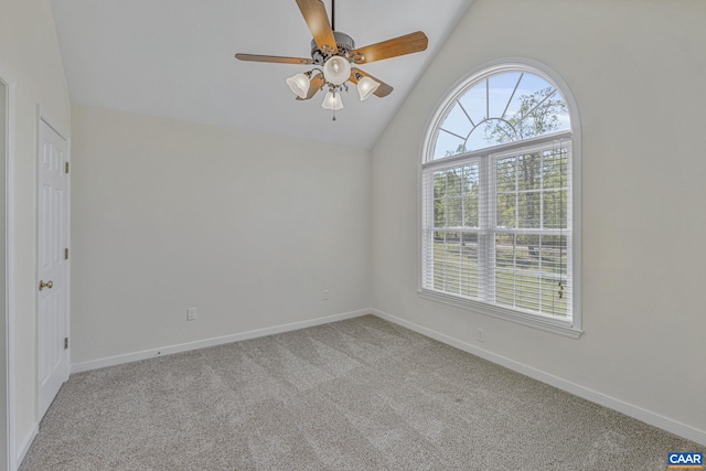 empty room featuring baseboards, vaulted ceiling, carpet flooring, and ceiling fan