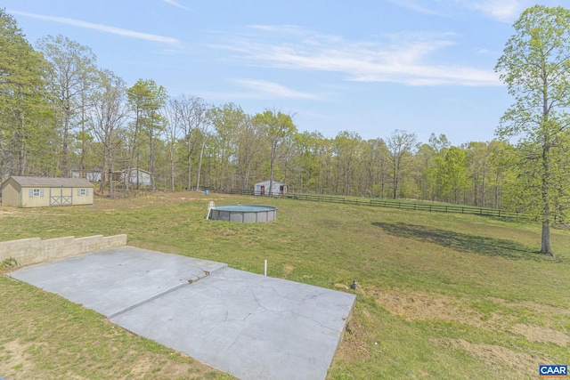 view of yard with an outdoor structure, fence, an outdoor pool, and a patio