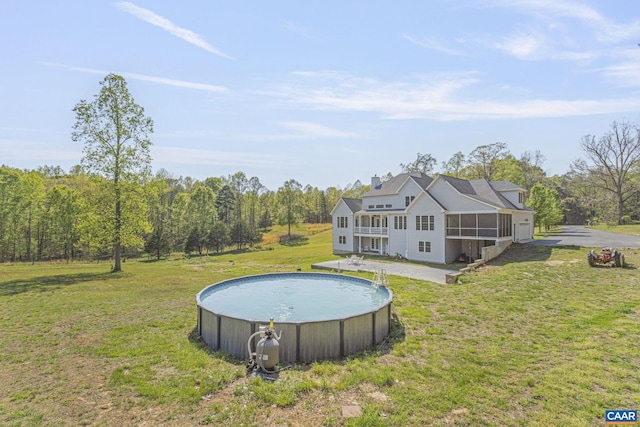 pool with a forest view, a lawn, and a sunroom