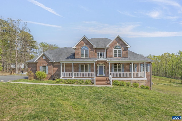 view of front of house with a front lawn, brick siding, roof with shingles, and covered porch