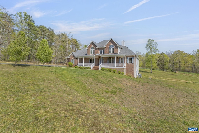 view of front of property featuring brick siding, a porch, and a front yard