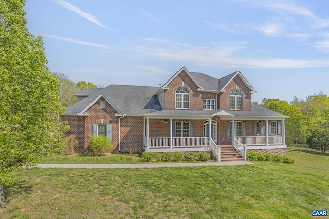 view of front of home with brick siding, roof with shingles, a porch, and a front yard