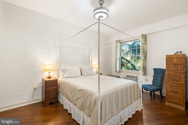 bedroom with baseboards and dark wood-type flooring