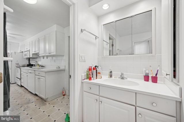 bathroom featuring backsplash, vanity, and recessed lighting