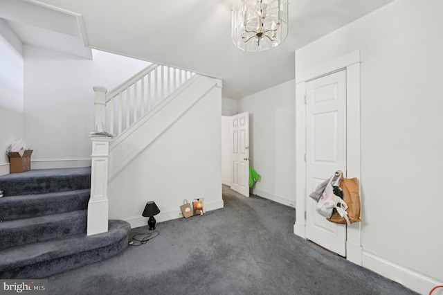 unfurnished living room featuring stairs, carpet flooring, a chandelier, and baseboards
