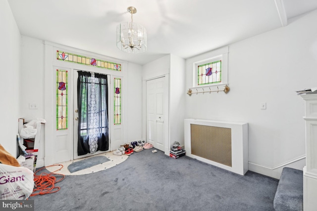 carpeted entryway with plenty of natural light, a chandelier, baseboards, and stairway