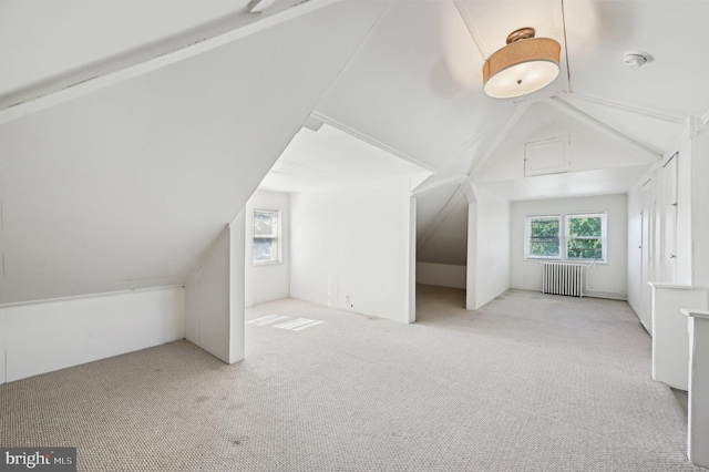additional living space featuring radiator, lofted ceiling, and carpet