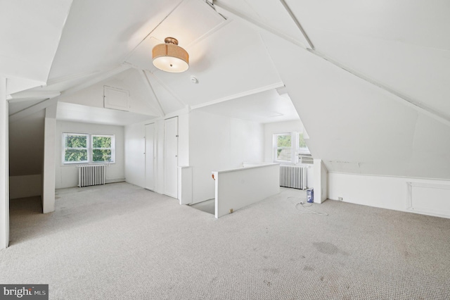 bonus room with radiator, carpet floors, vaulted ceiling, and healthy amount of natural light