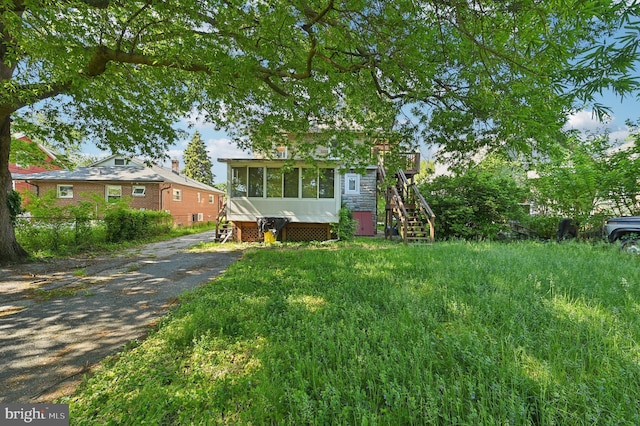 view of front of property featuring stairway and a sunroom
