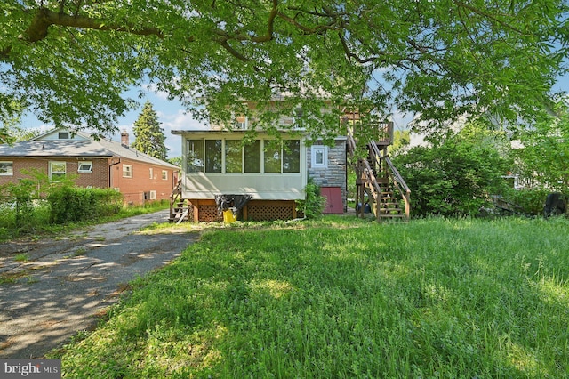 view of front facade featuring stairs and a sunroom