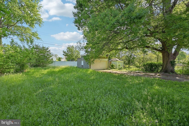 view of yard featuring fence and a garage