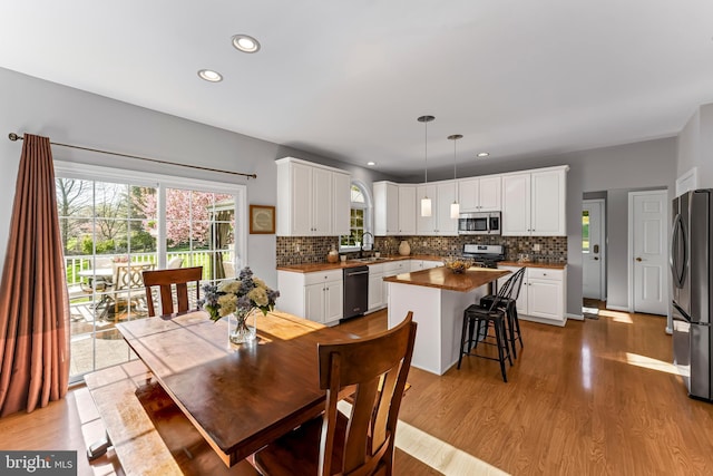 dining area featuring light wood-type flooring and recessed lighting